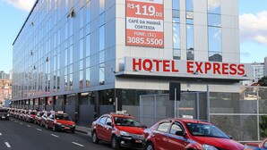 A modern hotel building with a large sign advertising a promotional rate. - Hotel Express Rodoviária (Porto Alegre)