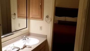 A bathroom with a sink, mirror, and wooden cabinets.