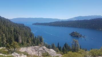 Vista panorámica de un lago rodeado de bosques densos y montañas.