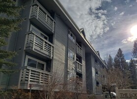 A multi-story building with balconies and a sign that reads "THE LODGE KINGSBURY CRE".