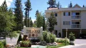 A sign for 'The Lodge' with a building in the background.