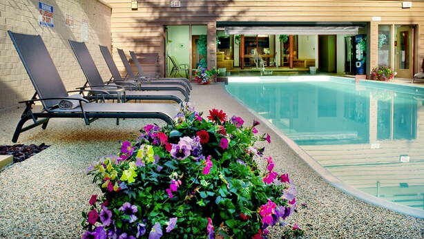 Uma área de piscina com espreguiçadeiras e um edifício com sinalização de saída.