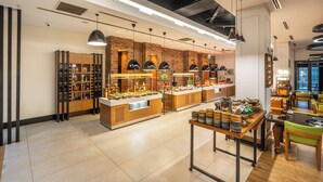 Un café moderno con pared de ladrillo, mostrador de madera e iluminación colgante.
