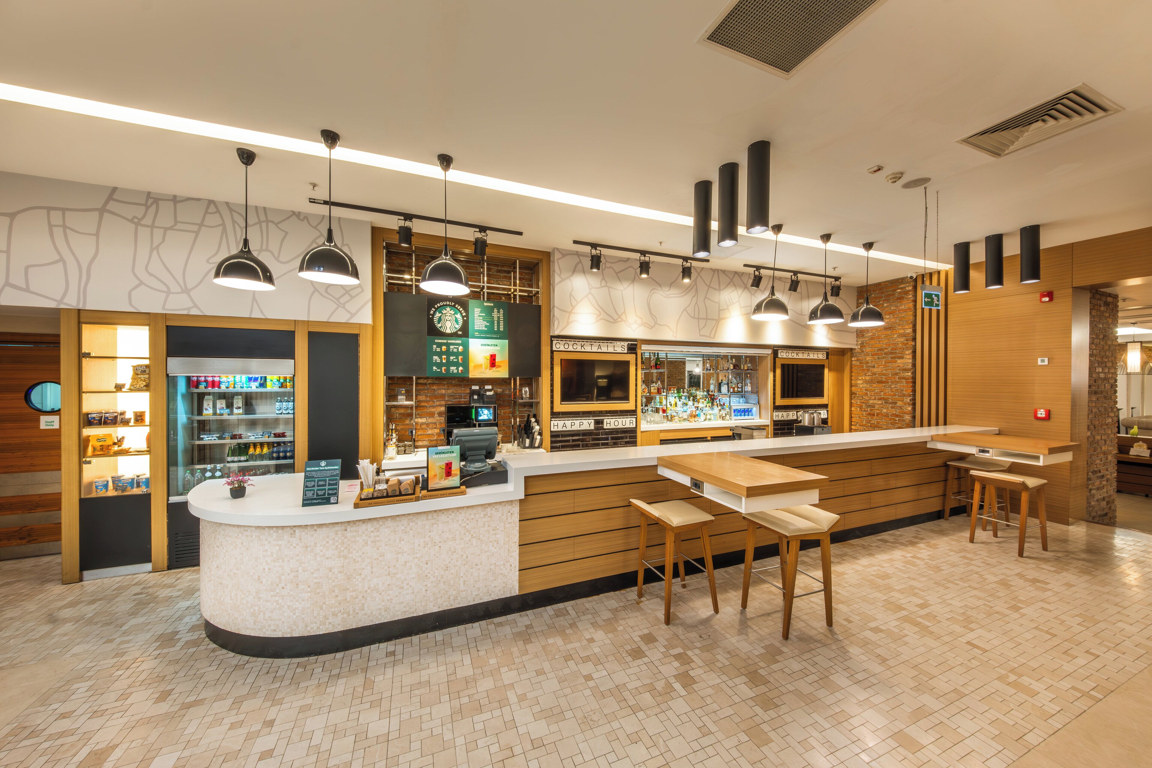 A modern bar area with a counter, stools, and a menu board.