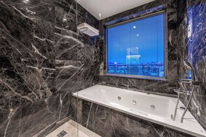 Suite, 1 King Bed, Smoking, Jetted Tub | Bathroom | Eco-friendly toiletries, hair dryer, slippers, towels