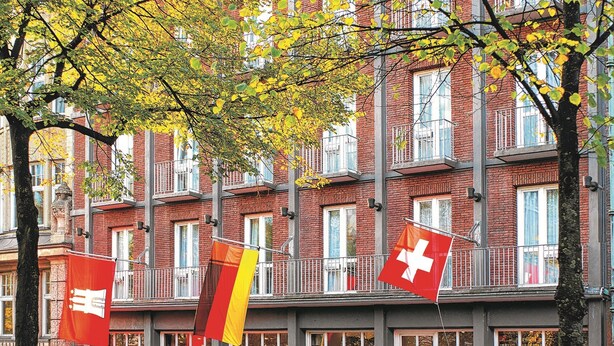 A building with multiple red awnings labeled "BASELER HOF RESTAURANT" and flags of Switzerland and Germany. - Palais Esplanade Hamburg - Adults Only (Hamburg)