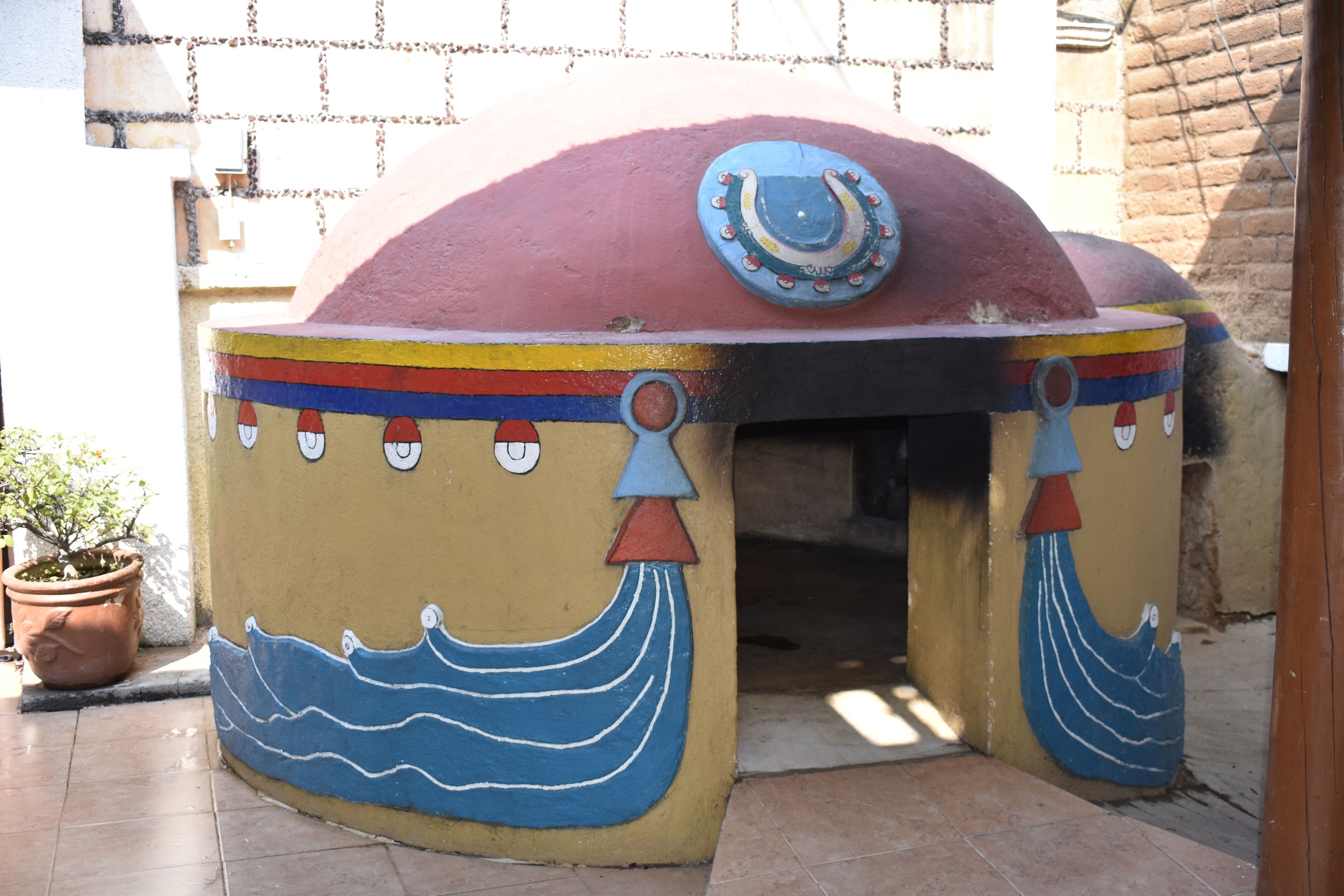 Una estructura colorida al aire libre con una parte superior en forma de herradura, posiblemente un edificio decorativo o funcional.