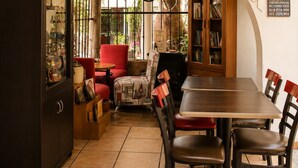 A cozy dining area with a wooden table, chairs, and a red pendant light. - Finca Chipitlán Hotel (Cuernavaca)