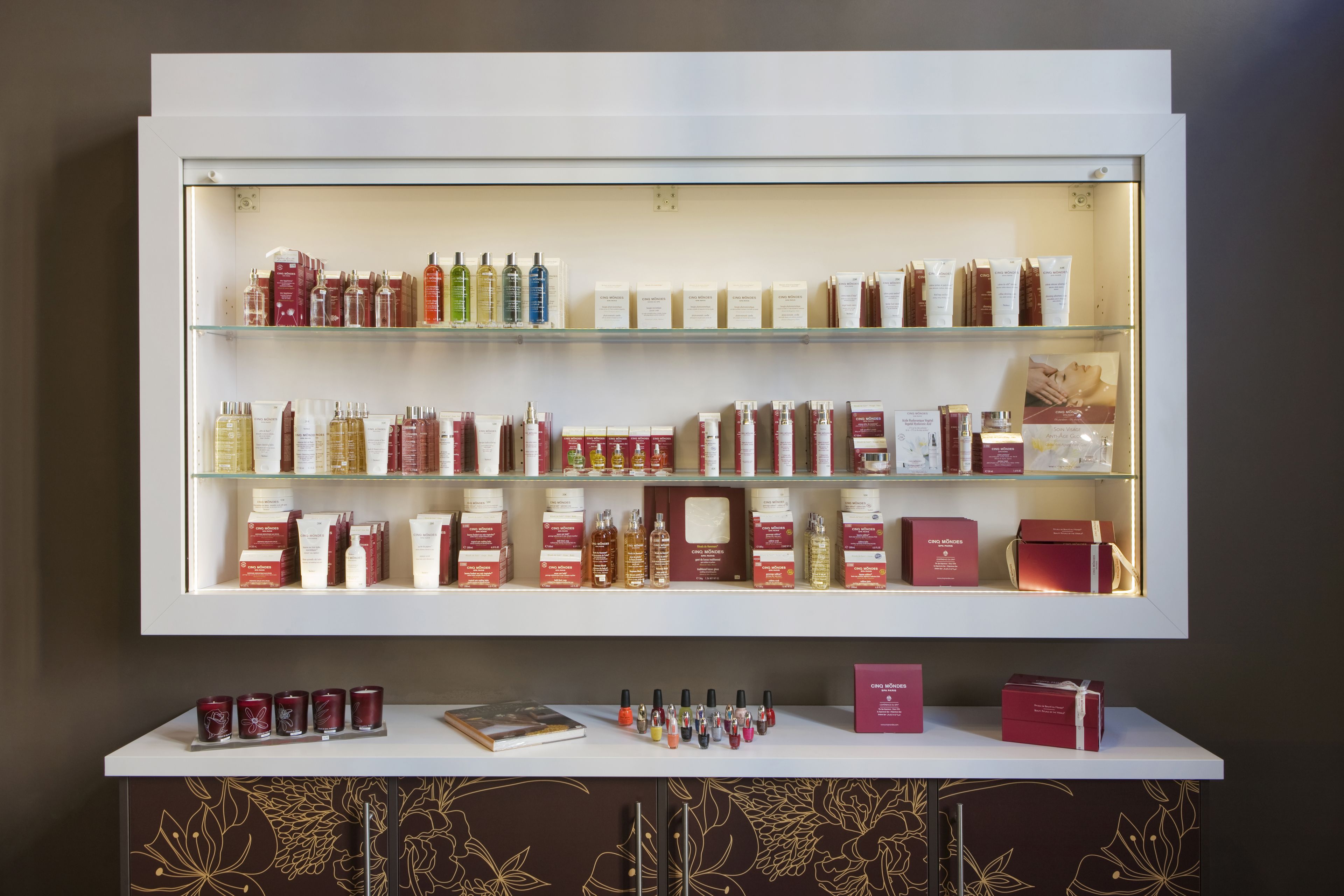 Une variété de produits de soins de la peau et de produits de beauté sont exposés sur des étagères et un comptoir.