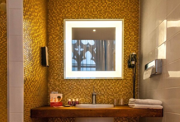 A bathroom with a tiled wall, a sink, a mirror, and a towel rack. - Martin’s Dream Hotel (Mons)