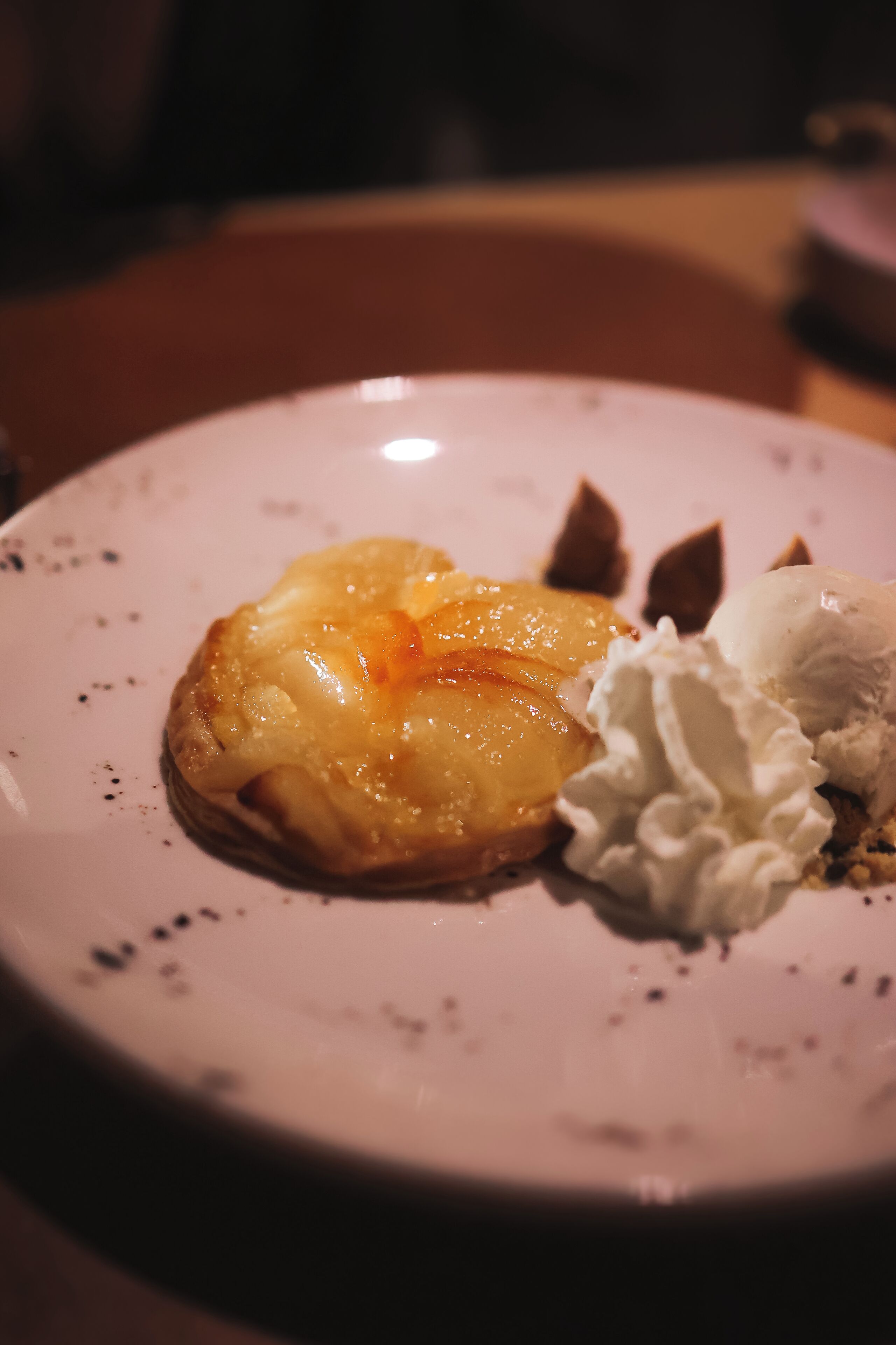 Une assiette à dessert avec une pâtisserie et de la crème fouettée.