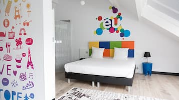 Un dormitorio moderno con una cama, una obra de arte colorida en la pared y una alfombra estampada.