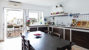 Une cuisine avec une table et des chaises, une fenêtre et une vue sur la ville.