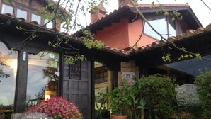 A rustic building with a stone pathway leading to a wooden door. - La Posada de Langre (Ribamontan al Mar)