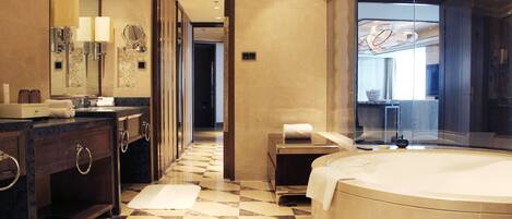 A modern bathroom with a large bathtub, a vanity with a mirror, and a checkered floor pattern.