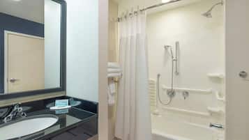 A bathroom with a sink, mirror, and bathtub.
