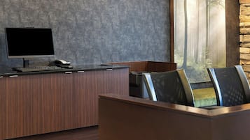 A modern office with a large desk, computer, and printer.