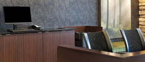A modern office with a large desk, computer, and printer.