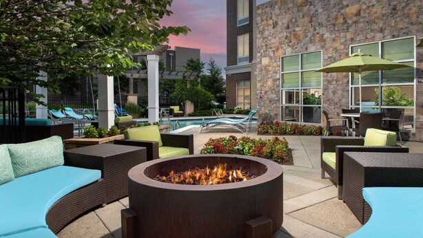 A courtyard with a fire pit, outdoor seating, and a pool. - Hilton Garden Inn Murfreesboro (Murfreesboro)