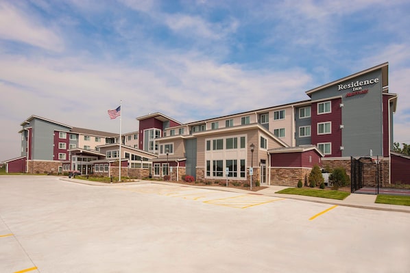 A multi-story hotel with a modern design, featuring a prominent entrance and a parking lot.