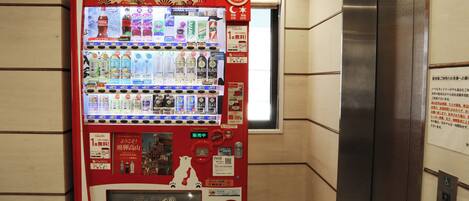 A vending machine with a 'Welcome to Takayama!' sign, various drink options, and a red power button.