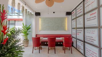 Ein modernes Interieur mit einer roten Bank, roten Stühlen und einem Deckenventilator.
