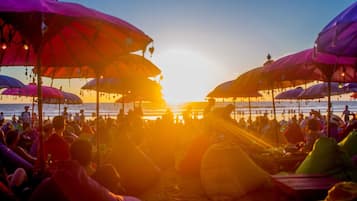 Perto da praia, espreguiçadeiras, guarda-sóis, toalhas de praia