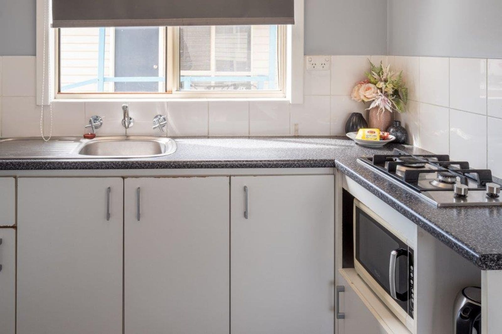 Una cocina moderna con un lavabo, estufa y armarios.