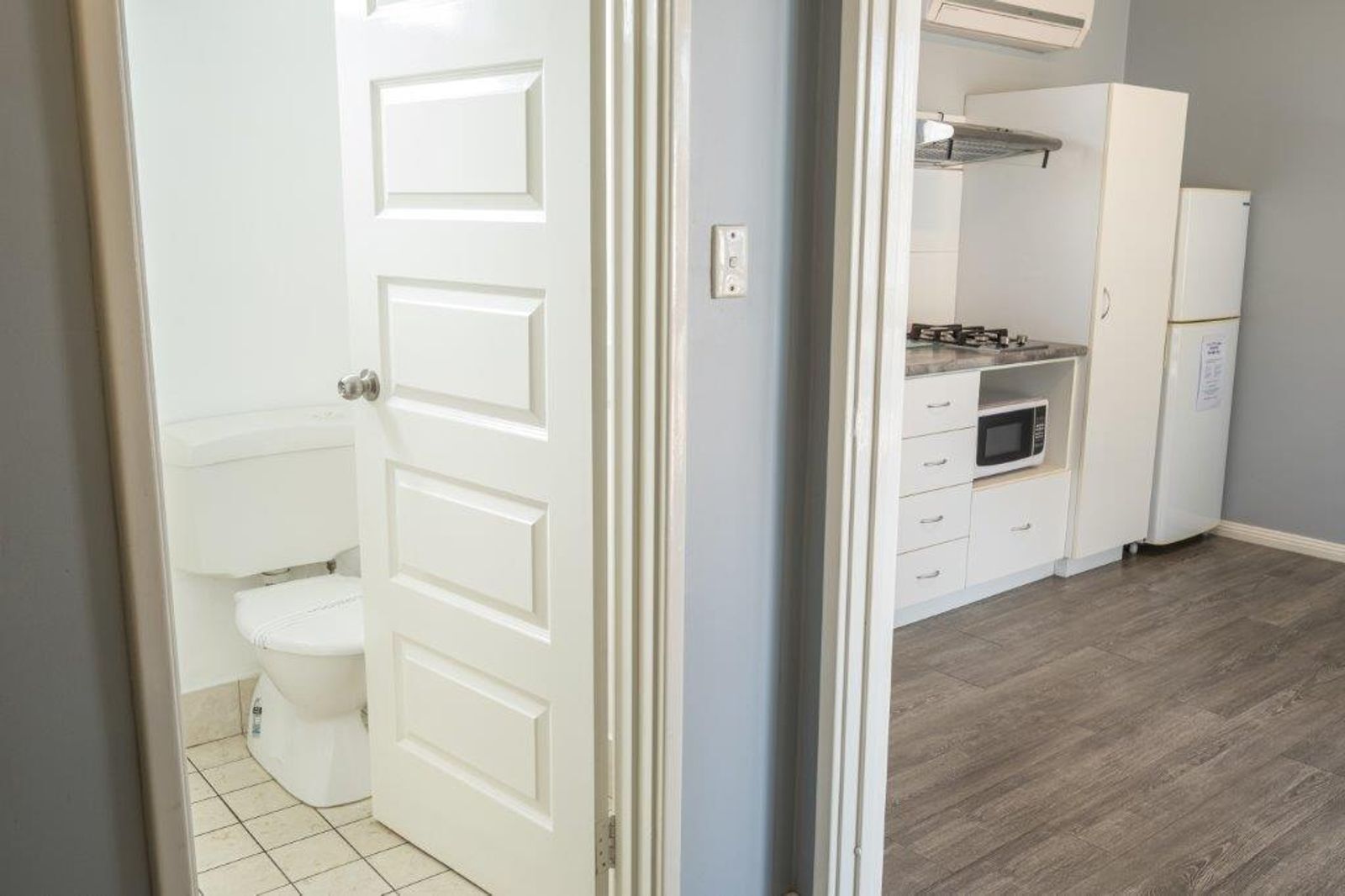 A small kitchen with a refrigerator, microwave, and cabinets.