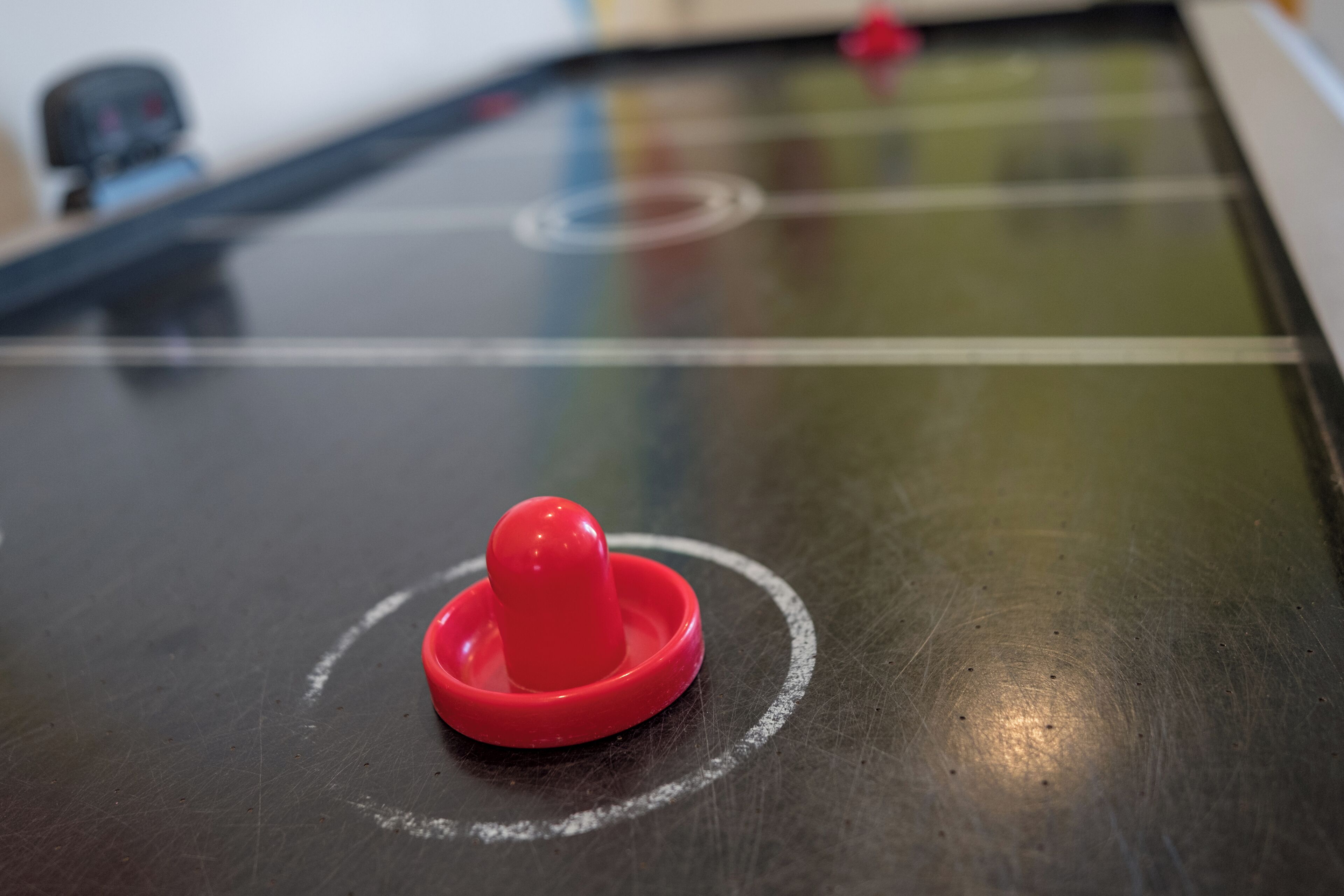 Primer plano de una mesa con un objeto rojo encima, posiblemente una pieza de juego o juguete.