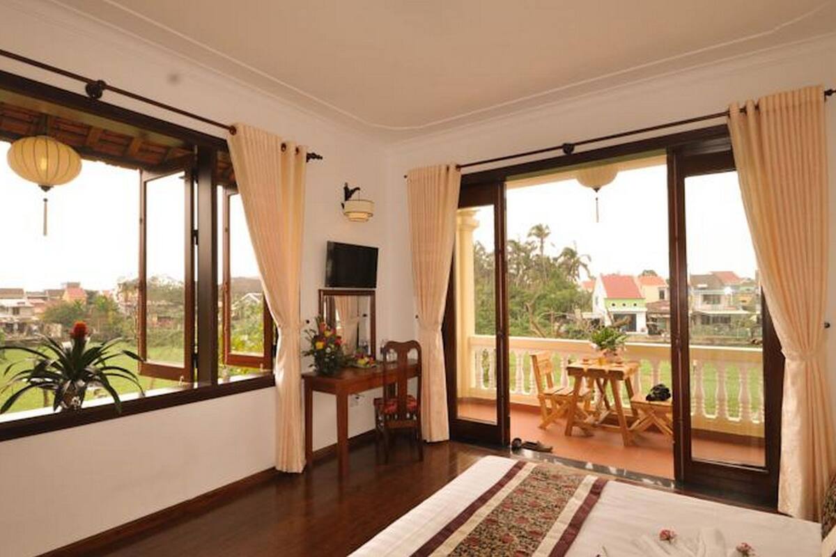 Deluxe Room, Garden View | Minibar, in-room safe, desk, iron/ironing board