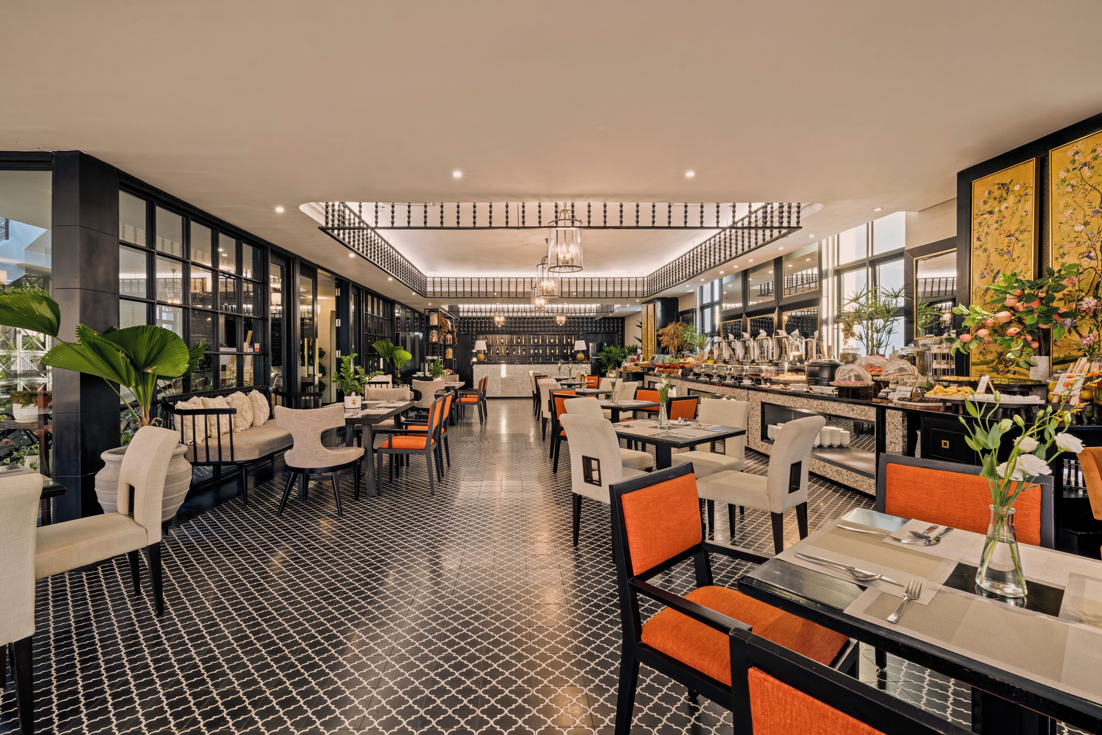 En rummelig restaurant med højt til loftet, moderne møbler og en central trappe.