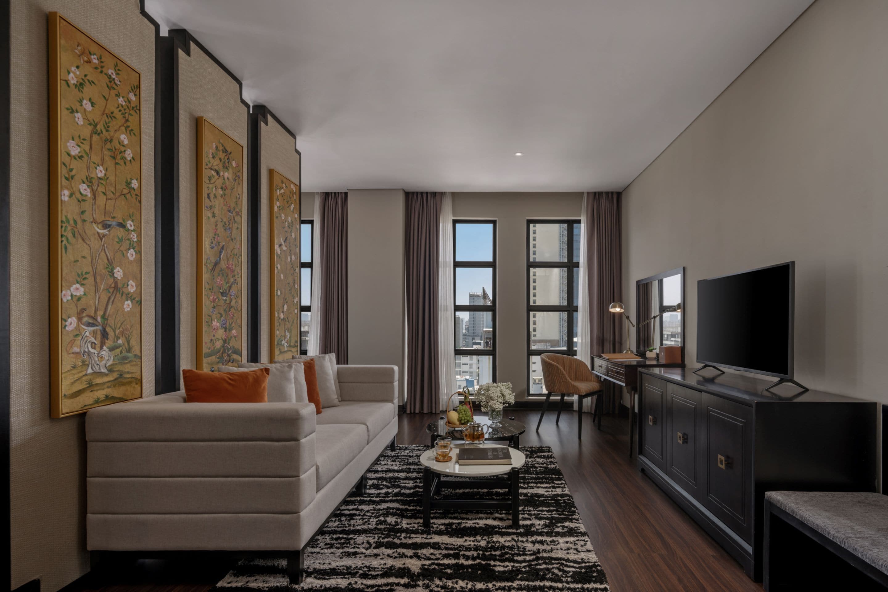 A modern living room with a sofa, coffee table, and artwork on the walls.