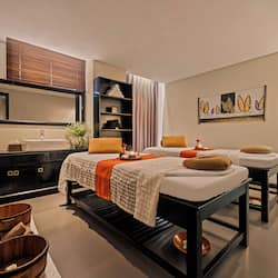 Relax in a serene bedroom with a large bed, bench, and stylish dresser.