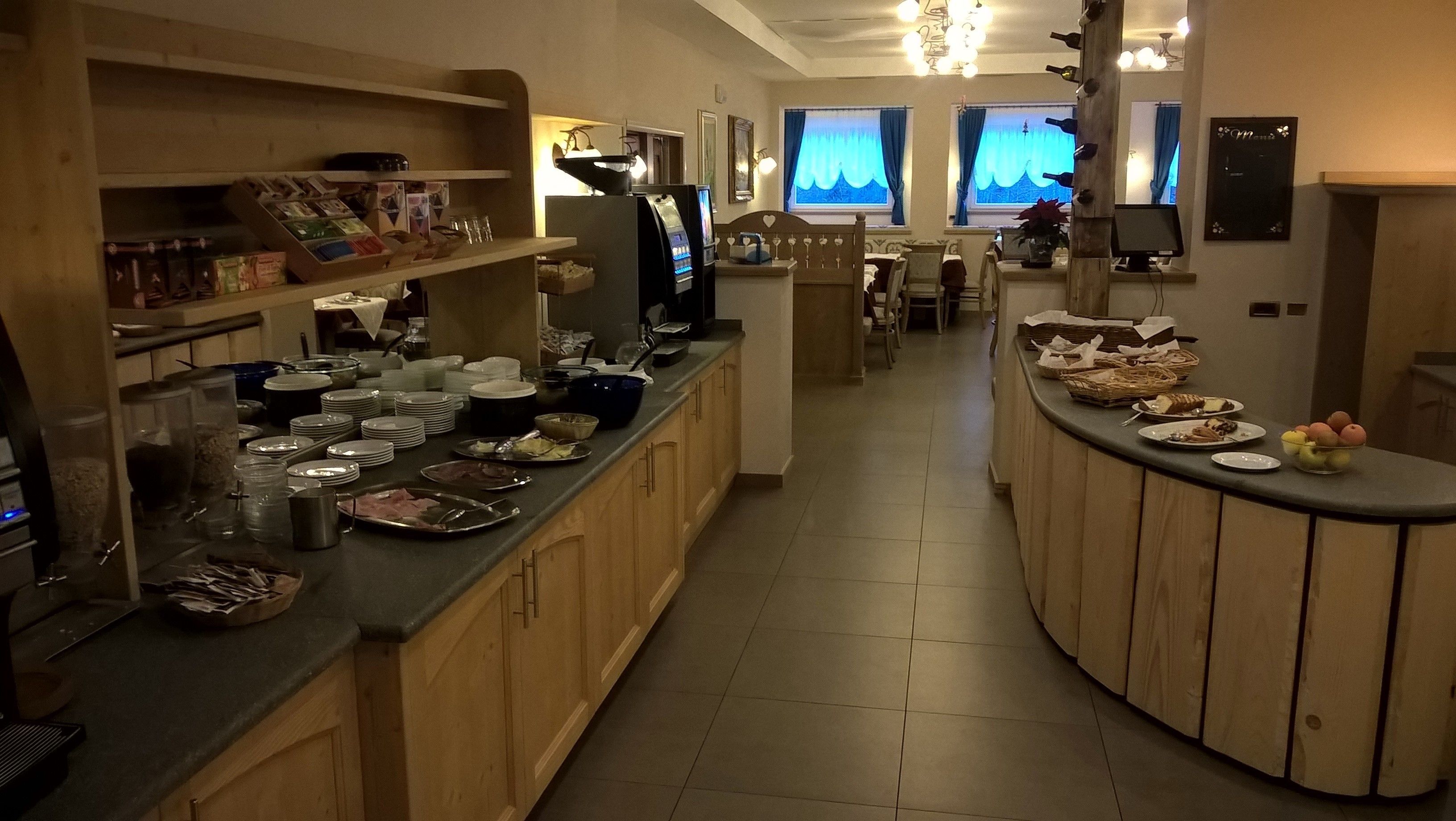 Una cucina d'albergo con un'area buffet, che include diversi cibi e utensili.