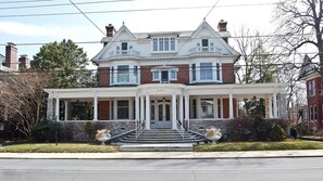 A two-story Victorian-style house with a front porch, a central entrance, and a symmetrical facade. - The Albanus Phillips Inn (Cambridge)