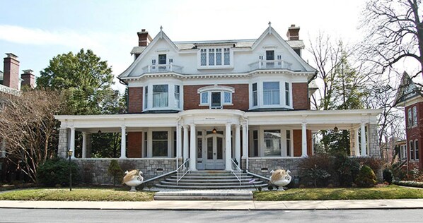 A large, two-story house with a prominent front porch, a bay window, and a symmetrical facade. - The Albanus Phillips Inn (Cambridge)