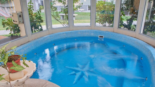 A hot tub with a clear view of the outdoors through large windows.