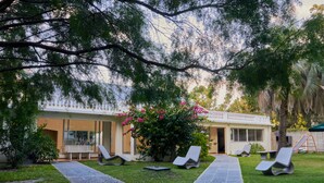 A modern building with a covered patio area, outdoor seating, and a well-maintained lawn.
