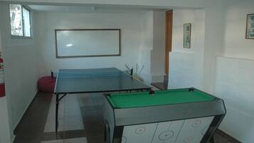 Une pièce équipée d’une table de billard, d’une table de snooker et d’un tableau blanc mural.