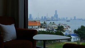 A room with a view of a city skyline and water. - Watermark Hotel Sizihwan (Kaohsiung)