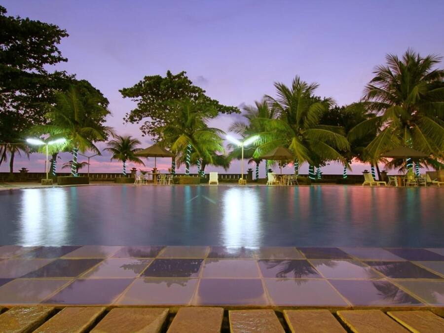 Una piscina al aire libre, sombrillas, sillones reclinables de piscina