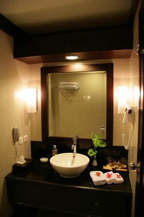 A hotel bathroom with a large sink, a mirror, a hairdryer, and a telephone. - Hotel Pangeran Beach (Padang)