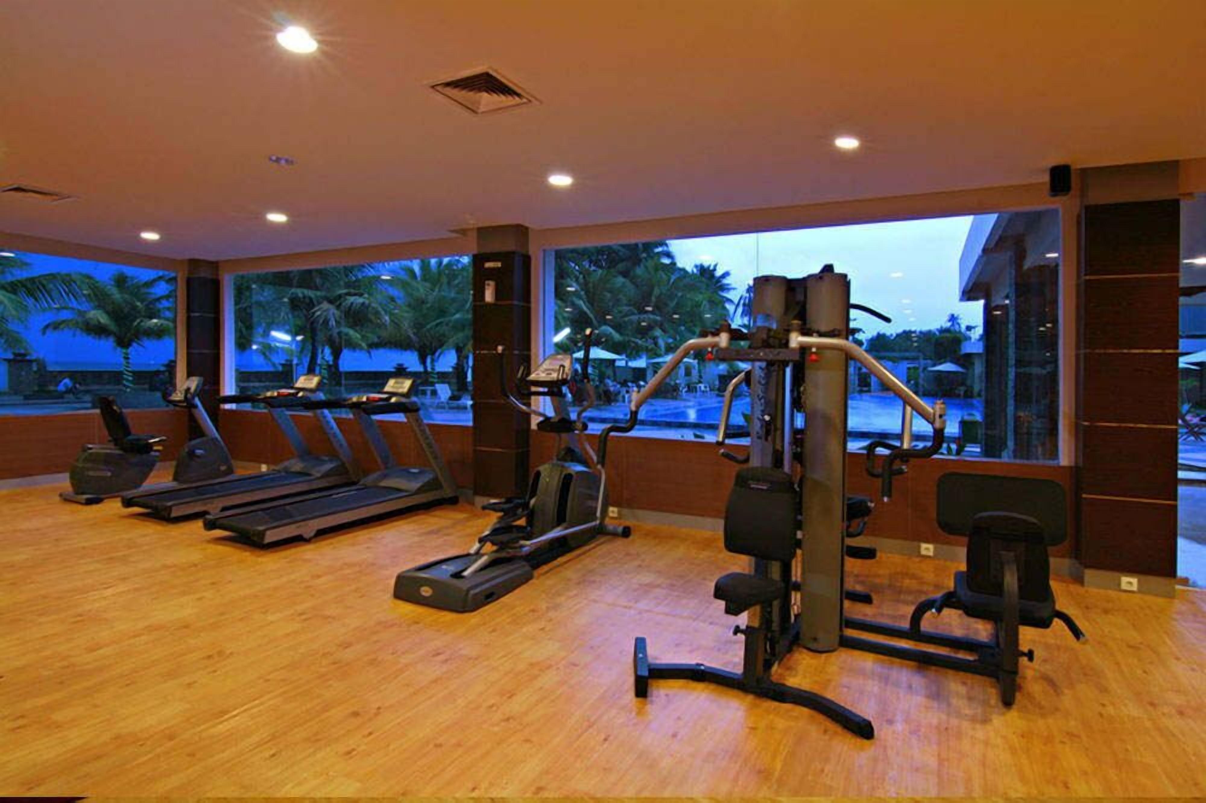 A gym with treadmills, elliptical machines, and weight equipment.