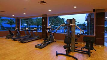 Un gimnasio con cintas de correr, elípticas y equipo de pesas.