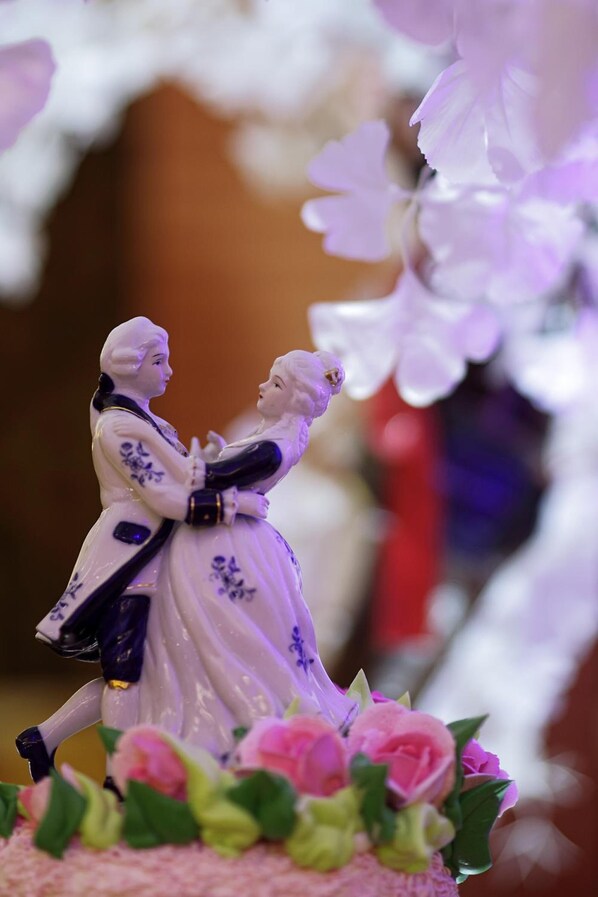 Un pastel de bodas con una figura decorativa encima.