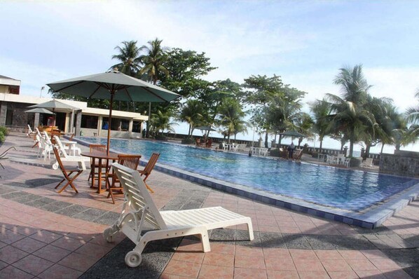 Una piscina al aire libre, sombrillas, tumbonas