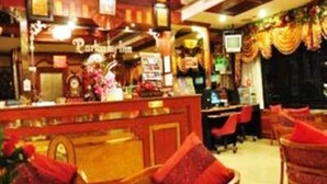 A hotel lobby with a reception desk, seating area, and decorative elements. - Parkway Inn (Bangkok)