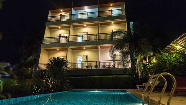 A multi-story hotel with a swimming pool, balconies, and outdoor seating areas. - Phuket Jula Place (Chalong)