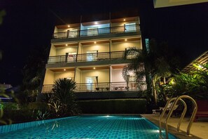 A multi-story hotel with a swimming pool, balconies, and outdoor seating areas. - Phuket Jula Place (Chalong)